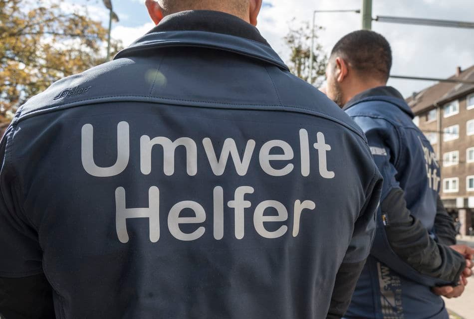 Mann mit Jacke auf dessen Rückseite Umwelthelfer steht