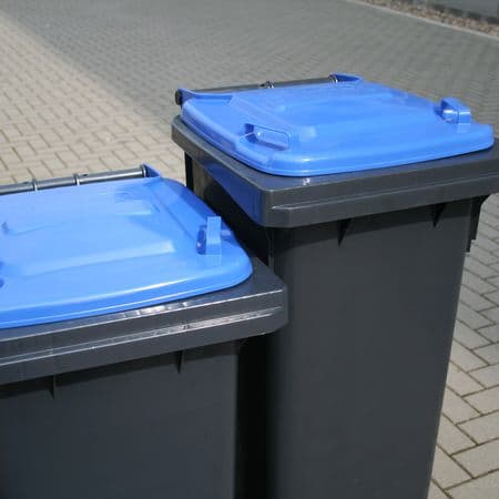 Zwei graue Mülltonnen mit blauen Deckeln zur Sammlung von Altpap