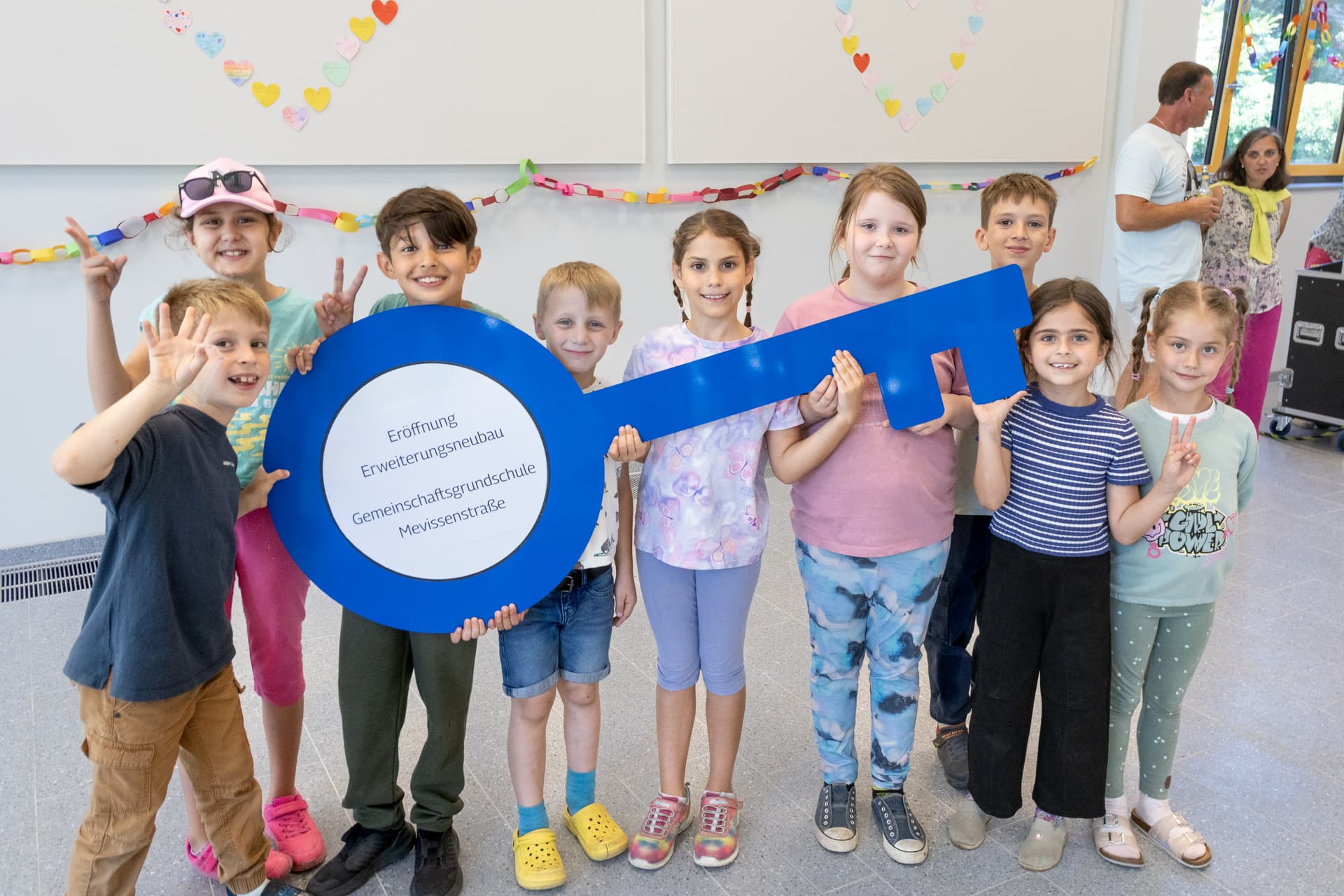 Strahlende Gesichter zur feierlichen Eröffnung: Schülerinnen und Schüler der Gemeinschaftsgrundschule Mevissenstraße präsentieren symbolisch den Schlüssel zum neuen Erweiterungsneubau