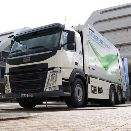 Großes Elektro-Müllfahrzeug, im Hintergrund das H2-Office im Innenhafen