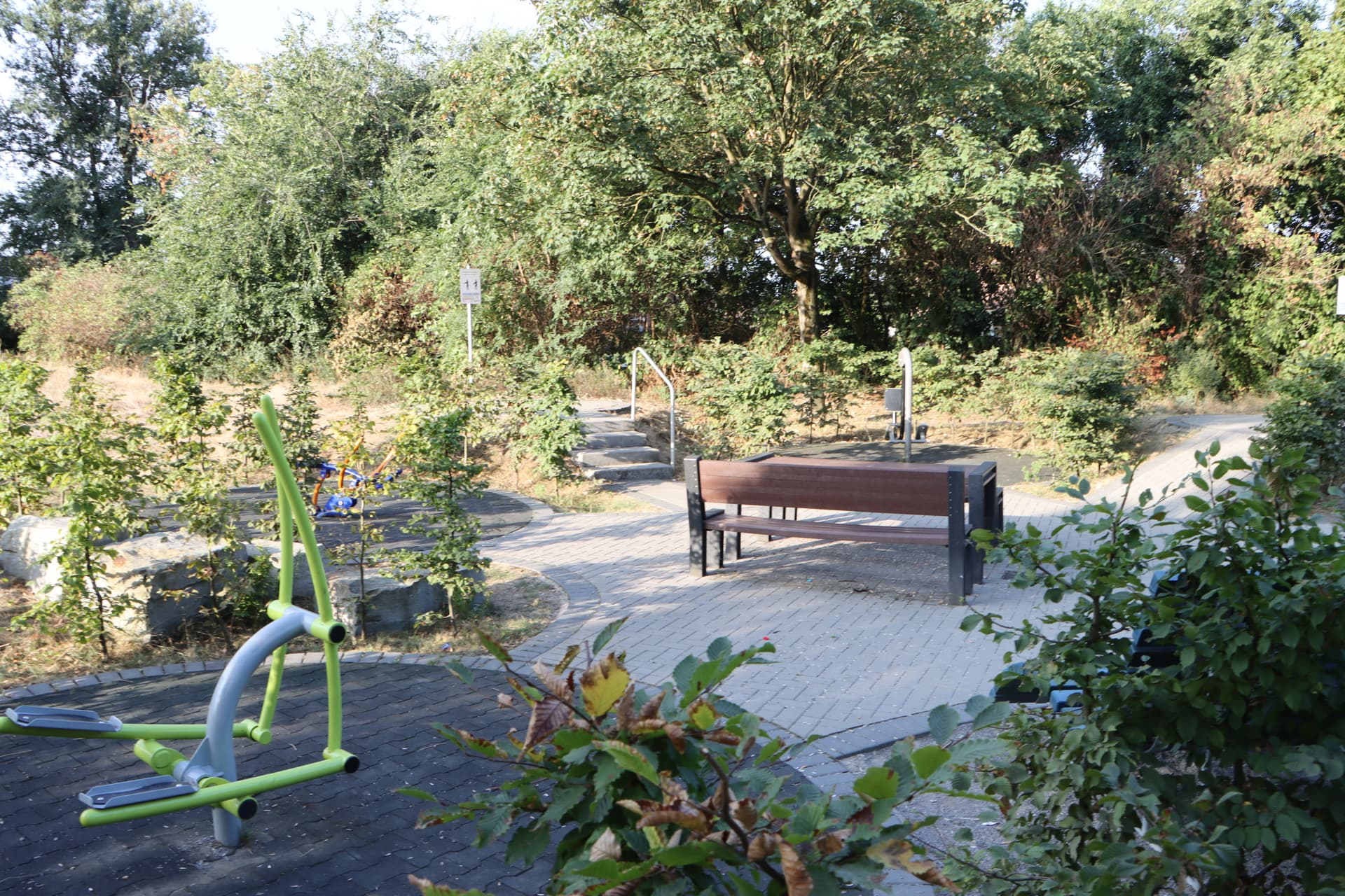 Trainigsgeräte und Bänke zum Ausruhen auf einem Mehrgenerationenspielplatz