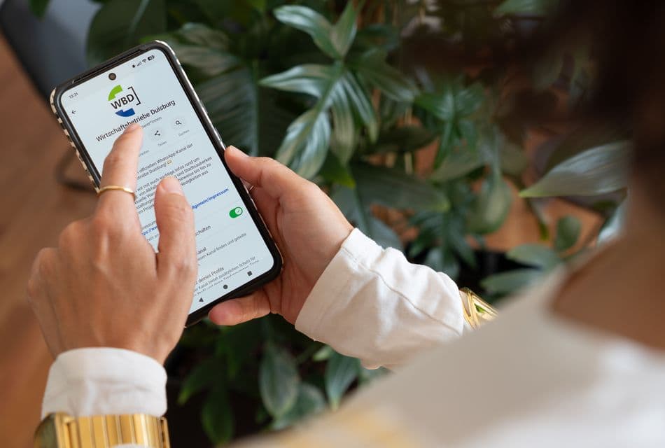 WhatsApp Frau schaut auf ein Smartphone mit WhatsApp-Kanal.